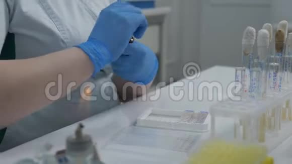 戴着手套的微生物学家在医学实验室里研究细菌视频的预览图