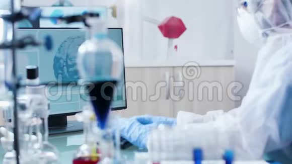 在现代实验室里科学家穿着工作服在电脑键盘上打字视频的预览图