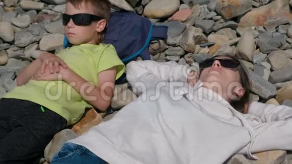 母亲和儿子在岩石上休息视频的预览图