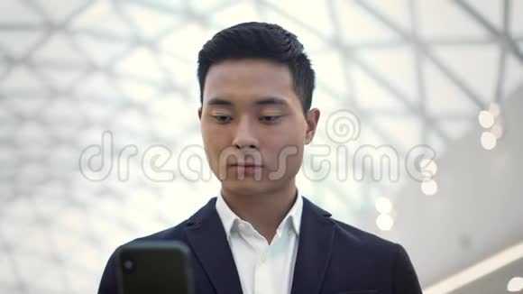 穿西装带手机走路的亚洲男性慢镜头视频的预览图