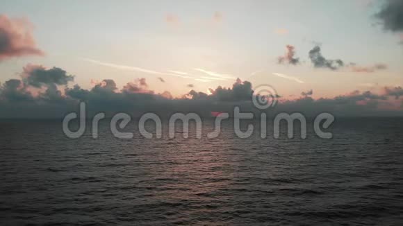 鸟瞰美丽的日落粉红色的阳光路和无风的大海粉色美丽日落下宁静海洋的无人机拍摄视频的预览图