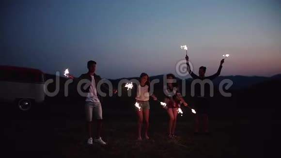 一群朋友在黄昏时站在户外闪闪发光慢动作视频的预览图