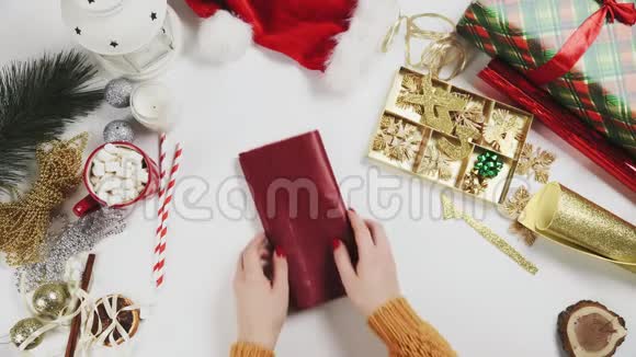 准备红纸包装圣诞礼物的女人视频的预览图
