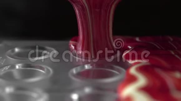 食物宏视频具有将液态白色巧克力倒入candys模具的纹理融化的巧克力制作视频的预览图