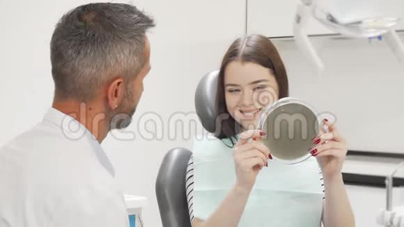 美丽幸福的女人体检后和牙医交谈视频的预览图