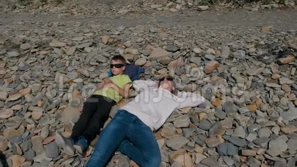 母亲和儿子在岩石上休息视频的预览图