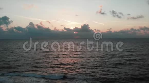 夏天的太阳落在美丽的地中海上海浪拍打着岩石海岸空中无人机视野视频的预览图