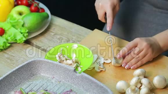 女用手在木板上切香姜菇视频的预览图