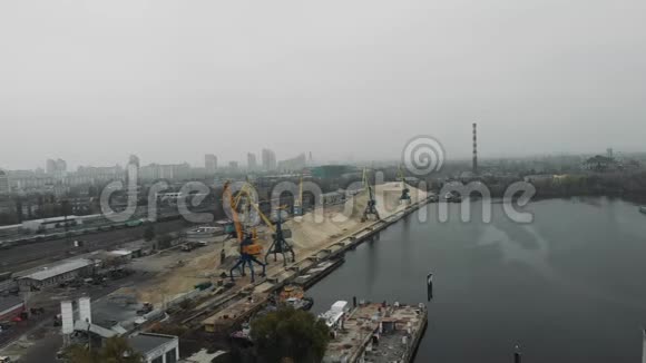 城市工业园区的建筑起重机从驳船到运砂车空中景观视频的预览图