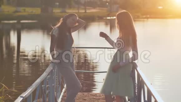 日落时分湖边的两个金发女孩和女朋友视频的预览图