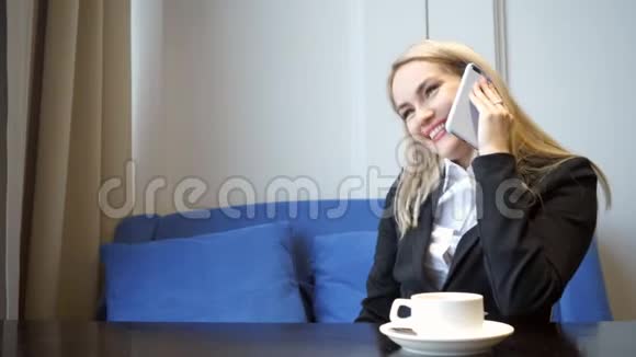 成功的商务女性使用智能手机并在咖啡厅获得晋升视频的预览图