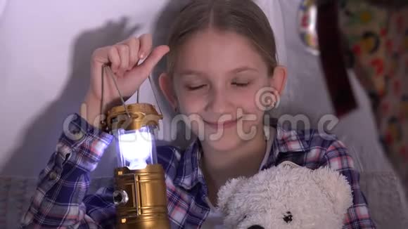 孩子拿着手电筒在帐篷里玩孩子们在夜晚冒险微笑的肖像视频的预览图