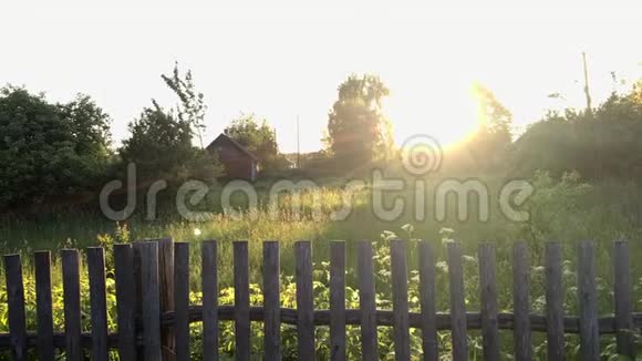 阳光下的乡村景观旧的木栅栏后面还有一块草坪视频的预览图