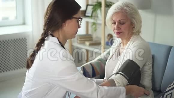 在家中测量她病人血压的年轻专家视频的预览图