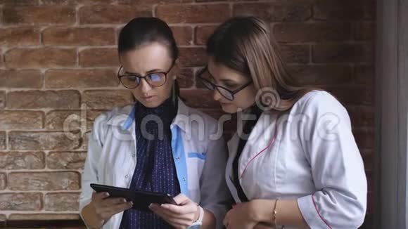 女医生和女实习生根据药片上的病史讨论病人的诊断视频的预览图