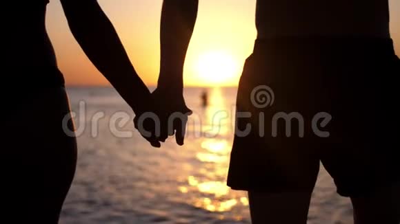 一对夫妇手牵着手在夕阳下散步视频的预览图