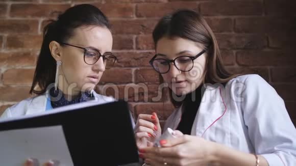 女医生和女实习生谈论病人的诊断女实习生看了包装上的注解视频的预览图