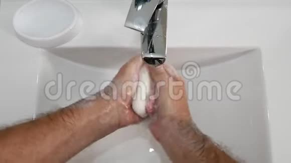 男人用大量肥皂在浴室用冷水洗手视频的预览图
