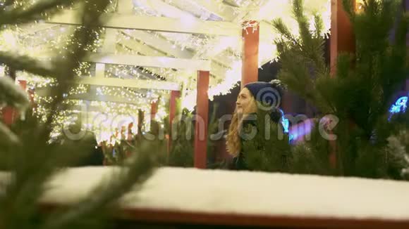 年轻女子欣赏街上的圣诞灯女性看户外咖啡馆的装饰视频的预览图