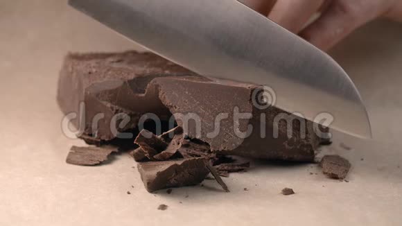 小块巧克力的厨师用小刀慢慢切用巧克力烹饪甜糕点糖果视频的预览图