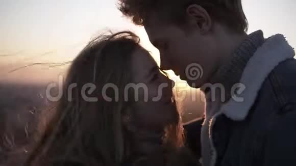 特写镜头浪漫的年轻夫妇面对面地站在太阳的背光下同时站在视频的预览图