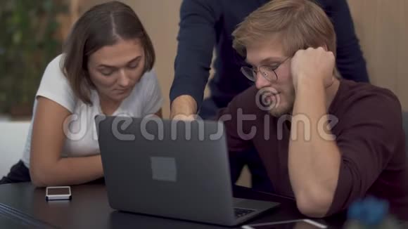 女人不同意她的同事的看法他在同事的笔记本电脑上显示一些新的有用信息视频的预览图