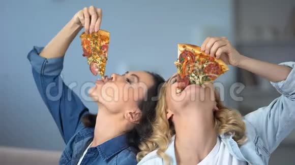 微笑女人贪婪地吃美味的披萨快餐成瘾不健康的饮食视频的预览图