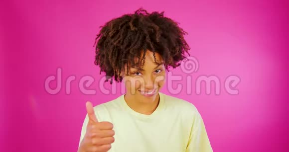 一个非洲女孩在粉色背景下竖起大拇指回顾评论客户反馈视频的预览图