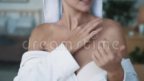 贴身穿浴袍的女人在肩膀上涂抹奶油动作缓慢视频的预览图