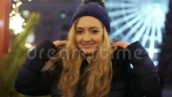 戴着冬帽的年轻微笑女子在室外镜头中交谈的肖像视频的预览图