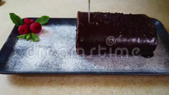 女人把巧克力卷切在厨房里盘子上的瑞士卷视频的预览图