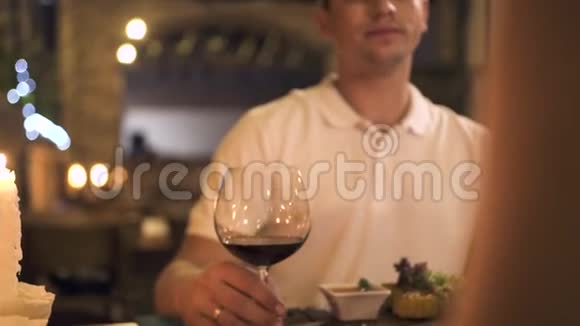 帅哥在餐厅为两人准备的浪漫晚餐上用红酒杯举杯一对爱喝酒的情侣视频的预览图