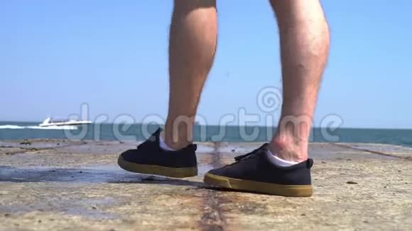 腿特写海边防波堤概念休闲腿的年轻人走过码头船骑交叉视频的预览图