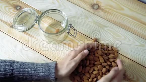 女性的手在玻璃罐里移动杏仁顶部视图视频的预览图