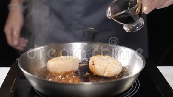 餐馆里的海鲜素食观念专业厨师手套在煎锅中的扇贝上浇酱汁慢慢视频的预览图