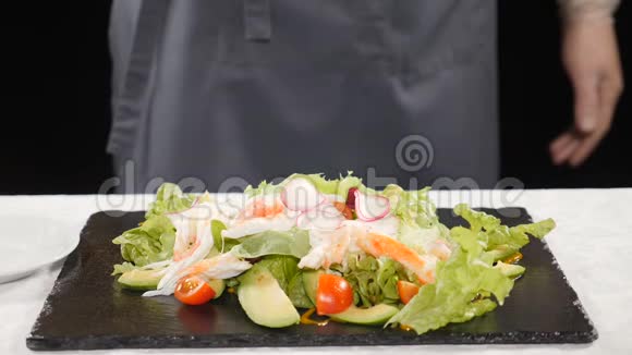 健康食品和素食理念厨师在生菜上浇酱汁蔬菜放在黑石板上慢慢视频的预览图