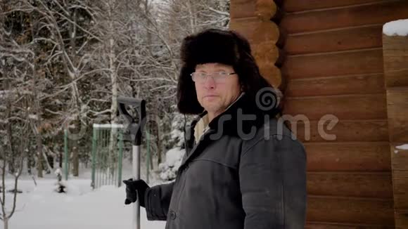 戴帽子的人和穿暖衣服的人站在冬天的家里拿着铲子视频的预览图