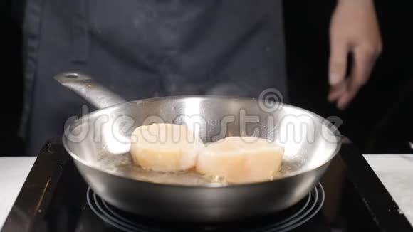 食物概念专业厨师在手套中缓慢地煎贝上面的白色蒸汽云快关门高清高清视频的预览图