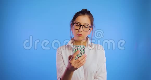 一个戴眼镜的女孩滚动新闻提要打开手机并推荐产品Chroma键审查视频的预览图
