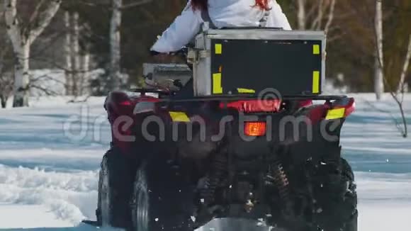 白天的冬天森林一个有姜发的女人白天骑着雪车背面视频的预览图