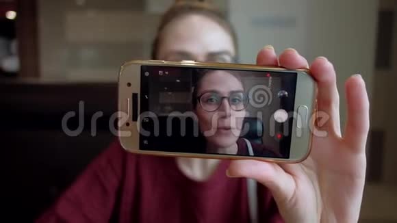 年轻的博客记录视频在智能手机上视频的预览图
