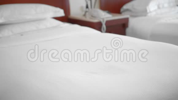 一名未被认出的成年老年妇女躺在酒店房间的床上躺在白色毛巾上服务和清洁的概念视频的预览图