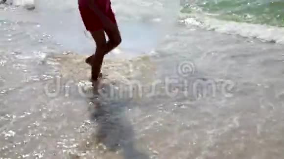 两个人拿着一个水球孩子在海浪中跳跃有孩子的家庭的海上假期视频的预览图