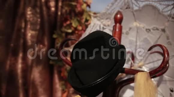 木架上挂着黑色的帽子黄色的围巾白色的敞开式花边伞视频的预览图