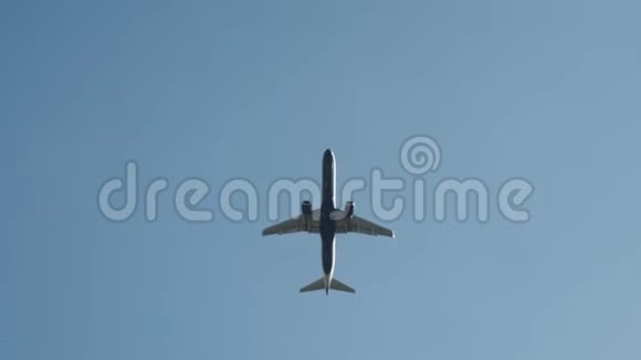 从底部看一架白色的大客机在晴朗的蓝天上飞行行动乘飞机去夏天视频的预览图