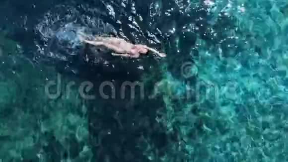 蓝色海洋中女子游泳的空中全景视频的预览图