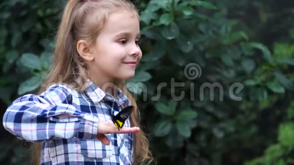 一个非常可爱的女孩手里拿着一只蝴蝶转过身来微笑着4K慢慢视频的预览图