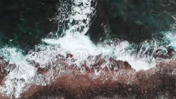 惊涛骇浪的高空俯视巨大的白色海浪撞击岩石海岸视频的预览图