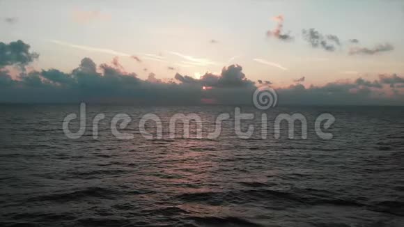 在粉红色的日落和阳光下Dran在美丽的海洋中飞过壮丽的多云天空视频的预览图