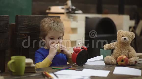 学校休息饥饿的孩子在教室里吃苹果玩纸飞机的小男孩小孩很高兴吃苹果视频的预览图
